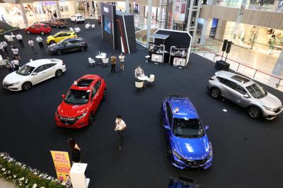 Sales Promotion Girl (SPG) berpose disisi unit mobil Honda saat pameran di Grand Atrium Pakuwon Mall Surabaya,  Jawa Timur, Jumat (30/4/2021).
