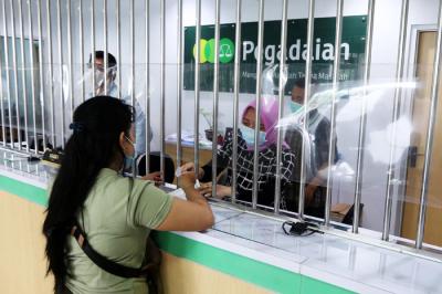 Suasana pelayanan offline di kantor Pegadaian Dinoyo, Surabaya, Jawa Timur, Jumat (30/4/2021).