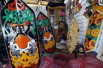 Perajin Talawang, Supiyan (53) menyelesaikan pembuatan kerajinan Talawang motif batang garing Dayak Kalimantan Tengah di Palangkaraya, Jumat (30/4/2021).
