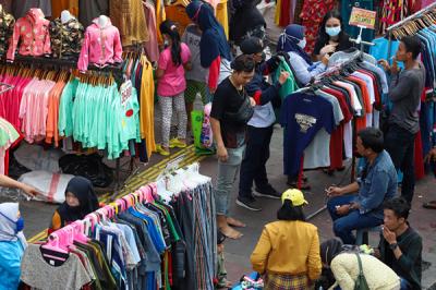 Warga memadati jembatan penyebrangan multiguna Tanah Abang untuk berbelanja di Jakarta Pusat, Minggu (2/5/2021).
