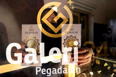 Karyawan menunjukan emas di Galeri 24 Pegadaian, Jakarta, Senin (3/5/2021).