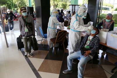 Pekerja Migran Indonesia (PMI) menjalani tes swab PCR saat tiba di Asrama Haji Sukolilo Surabaya, Jawa Timur, Rabu (5/5/2021).