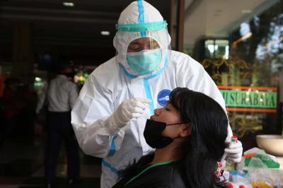 Pekerja Migran Indonesia (PMI) menjalani tes swab PCR saat tiba di Asrama Haji Sukolilo Surabaya, Jawa Timur, Rabu (5/5/2021).