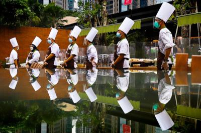 Pengunjung menikmati berbuka puasa dengan tetap mematuhi protokol kesehatan di hutan Kota Plataran Senayan, Jakarta Pusat, Rabu (5/5/2021).