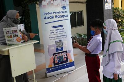 Siswa SD Al Falah Surabaya melakukan Scan QRIS ketika membayar infaq dan sedekah Ramadan di SD Al Falah Surabaya, Jawa Timur, Rabu (5/5/2021).