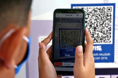 Siswa SD Al Falah Surabaya melakukan Scan QRIS ketika membayar infaq dan sedekah Ramadan di SD Al Falah Surabaya, Jawa Timur, Rabu (5/5/2021).