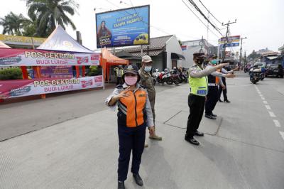 Petugas gabungan mengatur lalu lintas hari pertama penyekatan larangan mudik di perbatasan Jakarta-Tangerang di Jalan Ciledug Raya, Jakarta, Kamis (6/5/2021).
