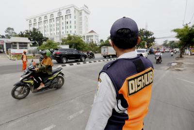 Petugas gabungan mengatur lalu lintas hari pertama penyekatan larangan mudik di perbatasan Jakarta-Tangerang di Jalan Ciledug Raya, Jakarta, Kamis (6/5/2021).