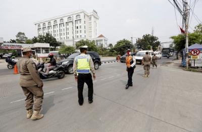 Petugas gabungan mengatur lalu lintas hari pertama penyekatan larangan mudik di perbatasan Jakarta-Tangerang di Jalan Ciledug Raya, Jakarta, Kamis (6/5/2021).