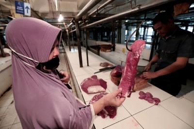 Pedagang memotong daging di Pasar Kramat Jati, Jakarta Timur, Jumat (7/5/2021).