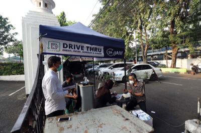 Warga membayar zakat di tenda pelayanan penyaluran zakat fitrah di Masjid Al-Azhar, Jakarta, Jumat (7/5/2021).