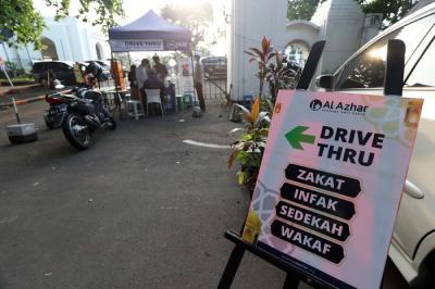 Warga membayar zakat di tenda pelayanan penyaluran zakat fitrah di Masjid Al-Azhar, Jakarta, Jumat (7/5/2021).