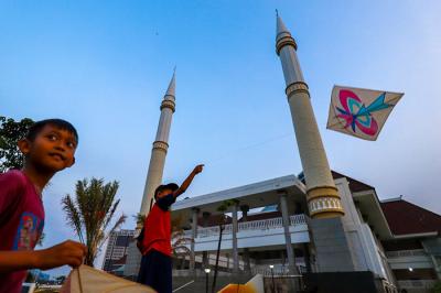 Anak-anak bermain layang-layang disaat senja menunggu berbuka puasa di sekitar Masjid Raya KH Hasyim Asyari, Jakarta Barat, Senin (10/5/2021).