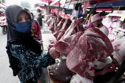 Pembeli memilih daging sapi di Pasar Kramat Jati, Jakarta Timur, Selasa (11/5/2021).