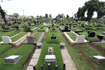 Pekerja makam tidur diatas makam di TPU Tanah Kusir, Jakarta, Selasa (11/5/2021).