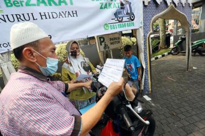 Warga menunaikan zakat fitrah di Gerai Zakat Infak dan Shodaqoh Drive Thru di Masjid Raya Nurul Hidayah, Tanah Kusir, Jakarta Selatan, Selasa (11/5/2021).