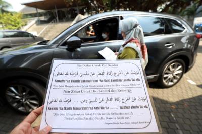 Warga menunaikan zakat fitrah di Gerai Zakat Infak dan Shodaqoh Drive Thru di Masjid Raya Nurul Hidayah, Tanah Kusir, Jakarta Selatan, Selasa (11/5/2021).