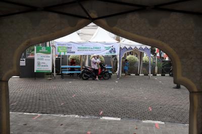Warga menunaikan zakat fitrah di Gerai Zakat Infak dan Shodaqoh Drive Thru di Masjid Raya Nurul Hidayah, Tanah Kusir, Jakarta Selatan, Selasa (11/5/2021).