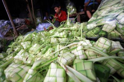Pedagang menyelesaikan pembuatan kulit ketupat yang dijual di kawasan Palmerah, Jakarta, Rabu (12/5/2021).