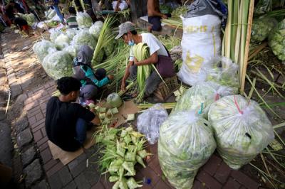 Pedagang menyelesaikan pembuatan kulit ketupat yang dijual di kawasan Palmerah, Jakarta, Rabu (12/5/2021).