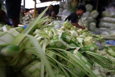 Pedagang menyelesaikan pembuatan kulit ketupat yang dijual di kawasan Palmerah, Jakarta, Rabu (12/5/2021).