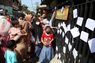 Puluhan anak dan warga mengambil amplop lebaran di Pagar Kejujuran di kediaman keluarga Trisnadi Marjan di Sidoarjo, Jawa Timur, Kamis (13/5/2021).