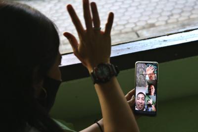 Pekerja Migran Indonesia Lilis Widyaningrum, bersilaturahmi dengan family lewat video call di ruang Karantina Asrama Haji Sukolilo Surabaya, Jumat (14/5/2021).