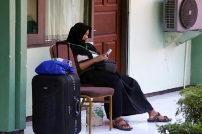 Pekerja Migran Indonesia Lilis Widyaningrum, bersilaturahmi dengan family lewat video call di ruang Karantina Asrama Haji Sukolilo Surabaya, Jumat (14/5/2021).