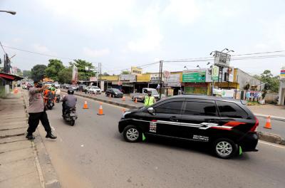 Petugas melakukan penyekatan kendaraan di Kawasan Jalan Raya Parung-Ciputat, Bojong Sari, Depok, Jawa Barat, Minggu (16/5/2021).