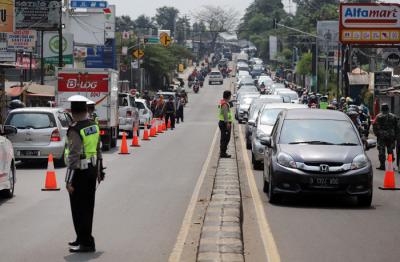 Petugas melakukan penyekatan kendaraan di Kawasan Jalan Raya Parung-Ciputat, Bojong Sari, Depok, Jawa Barat, Minggu (16/5/2021).
