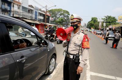 Petugas melakukan penyekatan kendaraan di Kawasan Jalan Raya Parung-Ciputat, Bojong Sari, Depok, Jawa Barat, Minggu (16/5/2021).