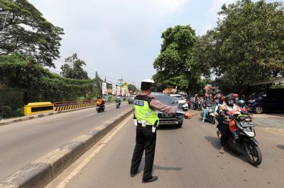 Petugas melakukan penyekatan kendaraan di Kawasan Jalan Raya Parung-Ciputat, Bojong Sari, Depok, Jawa Barat, Minggu (16/5/2021).