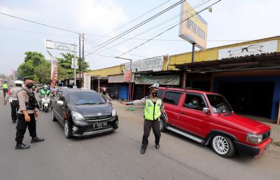 Petugas melakukan penyekatan kendaraan di Kawasan Jalan Raya Parung-Ciputat, Bojong Sari, Depok, Jawa Barat, Minggu (16/5/2021).