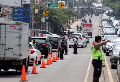 Petugas melakukan penyekatan kendaraan di Kawasan Jalan Raya Parung-Ciputat, Bojong Sari, Depok, Jawa Barat, Minggu (16/5/2021).