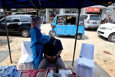 Petugas kesehatan mengambil sampel lendir pengendara saat tes swab antigen di Penyekatan Bojongsari, Depok, Jawa Barat, Minggu (16/5/2021).