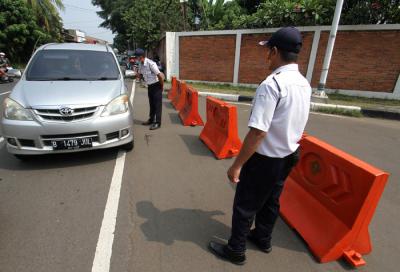 Petugas memberitahu TMII tutup kepada pengendara di TMII, Jakarta Timur, Minggu (16/5/2021).