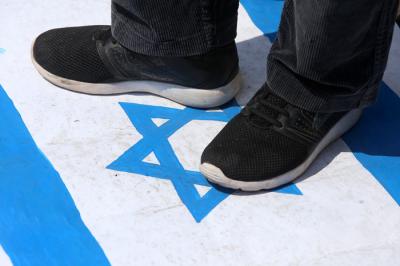 Massa aksi menginjak-injak bendera Israel saat Aksi Bela Palestina di Surabaya, Jawa Timur, Senin (17/5/2021).