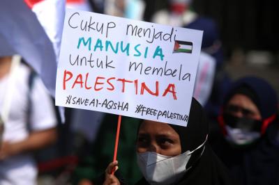 Massa aksi menginjak-injak bendera Israel saat Aksi Bela Palestina di Surabaya, Jawa Timur, Senin (17/5/2021).