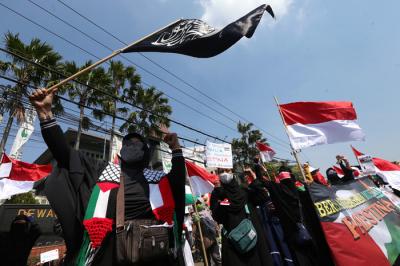 Massa aksi menginjak-injak bendera Israel saat Aksi Bela Palestina di Surabaya, Jawa Timur, Senin (17/5/2021).