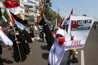 Massa aksi menginjak-injak bendera Israel saat Aksi Bela Palestina di Surabaya, Jawa Timur, Senin (17/5/2021).