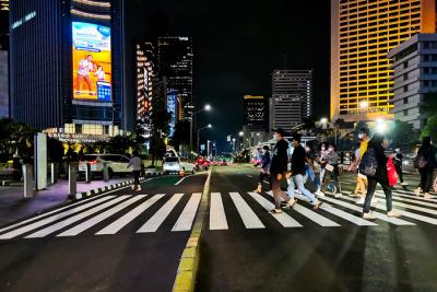 Warga pulang kerja melintasi pedestrian light controlled crossing (Pelican Crossing) di kawasan Sudirman, Jakarta Pusat, Senin (17/5/2021).