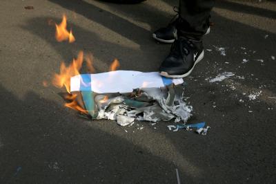 Pengunjuk rasa membakar kertas bergambar bendera Israel saat mengikuti aksi di depan Gedung Kedubes Amerika Serikat, Jakarta, Selasa (18/5/2021).