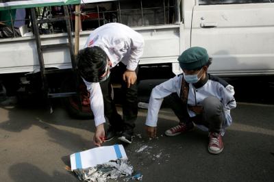 Pengunjuk rasa membakar kertas bergambar bendera Israel saat mengikuti aksi di depan Gedung Kedubes Amerika Serikat, Jakarta, Selasa (18/5/2021).