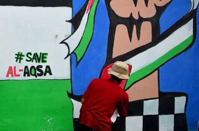 Remaja menyelesaikan pembuatan mural bertema solidaritas Palestina di Gang Jambu, Kedaung, Depok, Jawa Barat, Selasa (18/5/2021).