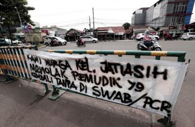 Pengendara melintasi spanduk bertuliskan himbauan kepada warga pemudik wajib test Covid-19 di kawasan Jatiasih, Kota Bekasi, Jawa Barat, Selasa (18/5/2021).