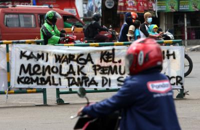 Pengendara melintasi spanduk bertuliskan himbauan kepada warga pemudik wajib test Covid-19 di kawasan Jatiasih, Kota Bekasi, Jawa Barat, Selasa (18/5/2021).