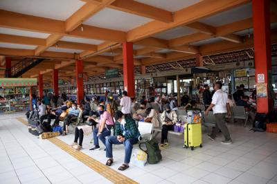 Petugas pemadam menyemprotkan cairan disinfektan kepada pemudik yang baru tiba di Terminal Kampung Rambutan, Jakarta, Rabu (19/5/2021).