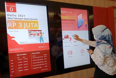 Nasabah melakukan setoran tunai tanpa kartu menggunakan OCTO Mobile di mesin Tarik Setor Tunai di Digital Lounge at Home CIMB Niaga, Jakarta, Kamis (20/5/2021).