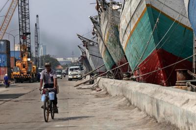 Pengendara melintasi kapal yang bersandar di Pelabuhan Sunda Kelapa, Jakart Utara, Jumat (21/5/2021).