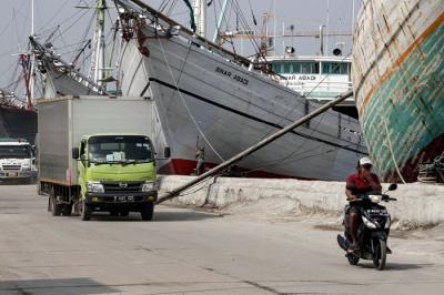 Pengendara melintasi kapal yang bersandar di Pelabuhan Sunda Kelapa, Jakart Utara, Jumat (21/5/2021).